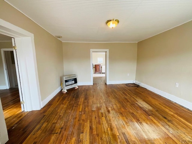 unfurnished living room featuring dark wood-style floors, baseboards, and heating unit