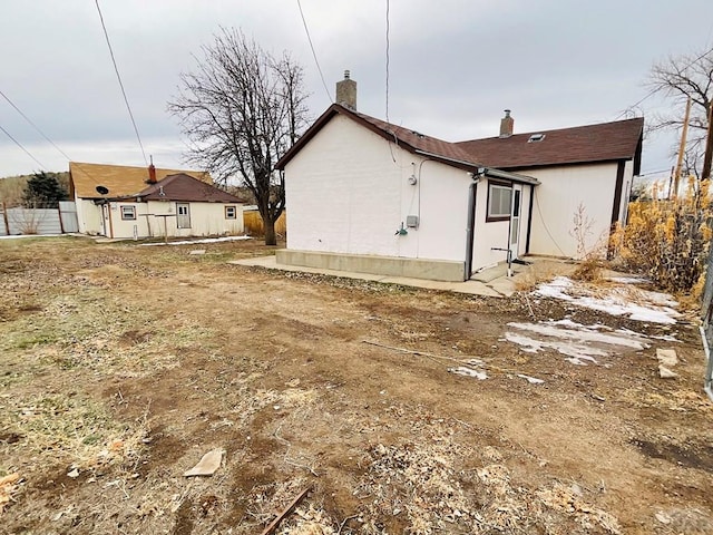 rear view of house featuring a chimney