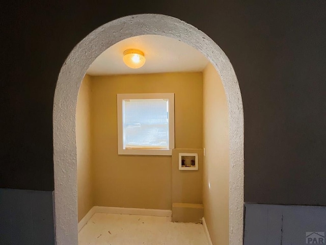 interior space featuring arched walkways and baseboards