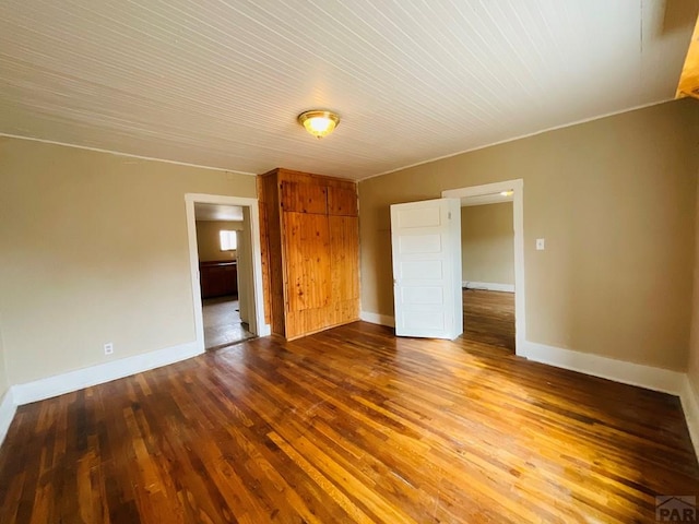 empty room featuring baseboards and wood finished floors