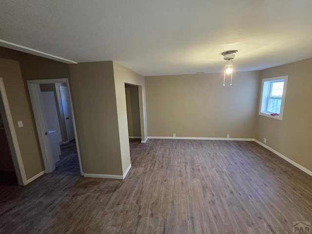 empty room featuring baseboards and wood finished floors