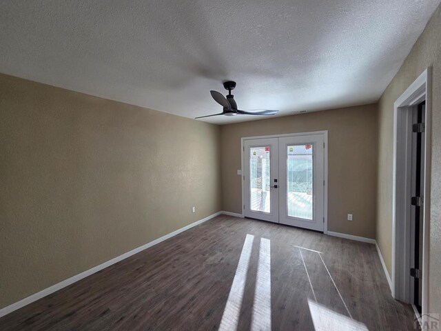 spare room featuring baseboards, wood finished floors, and french doors