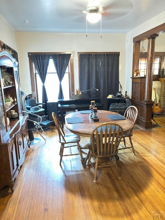 dining room with hardwood / wood-style floors, ornate columns, and ceiling fan
