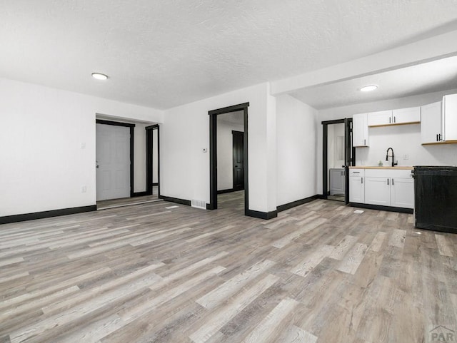 2803 Baltimore Ave, Pueblo, CO 81008 - unfurnished living room featuring light wood-style flooring, a textured ceiling, and recessed lighting