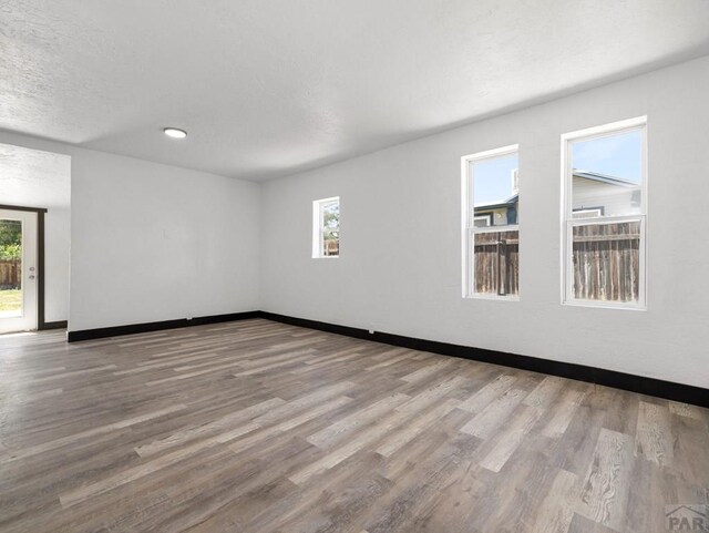 2803 Baltimore Ave, Pueblo, CO 81008 - empty room featuring healthy amount of natural light, wood finished floors, recessed lighting, and a textured ceiling