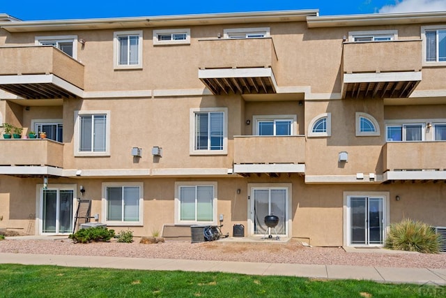 1447 Madison Ridge Hts Unit E, Colorado Springs, CO 80904 - back of house featuring stucco siding and a balcony
