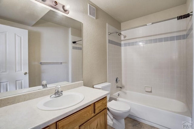 1447 Madison Ridge Hts Unit E, Colorado Springs, CO 80904 - full bathroom featuring a textured wall, vanity, toilet, and shower / bathtub combination