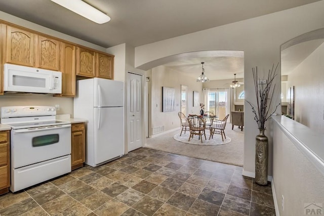1447 Madison Ridge Hts Unit E, Colorado Springs, CO 80904 - kitchen with white appliances, arched walkways, stone finish flooring, and baseboards
