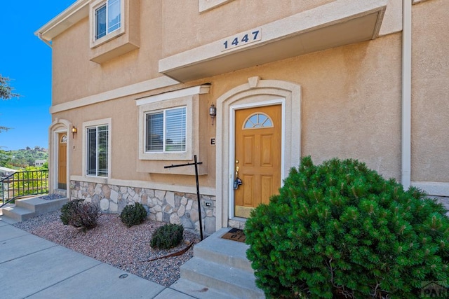 1447 Madison Ridge Hts Unit E, Colorado Springs, CO 80904 - view of exterior entry featuring stone siding and stucco siding