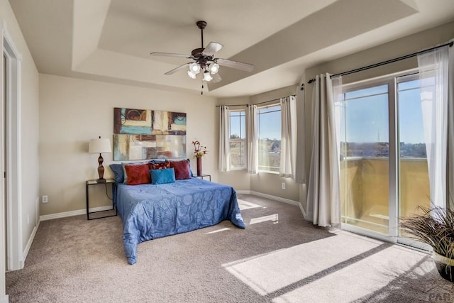 1447 Madison Ridge Hts Unit E, Colorado Springs, CO 80904 - bedroom featuring a raised ceiling, access to outside, carpet floors, and baseboards
