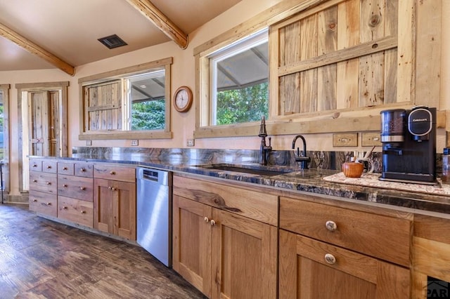 kitchen with stainless steel dishwasher, beam ceiling, a sink, dark wood-type flooring, and dark stone countertops