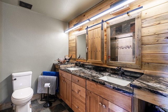 full bathroom with toilet, a tile shower, and double vanity