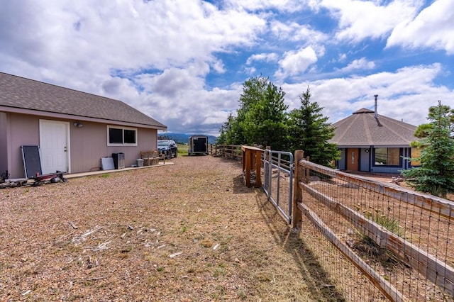 view of yard featuring fence and an outbuilding