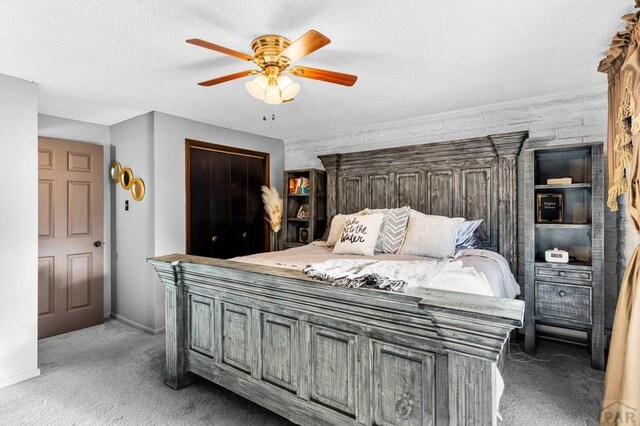 bedroom with baseboards, ceiling fan, a textured ceiling, dark carpet, and a closet