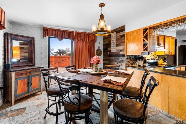 dining space with a chandelier and stone tile flooring