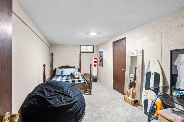 bedroom featuring a textured ceiling and carpet floors