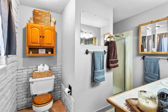 full bathroom with a textured ceiling, toilet, vanity, tile patterned floors, and a stall shower