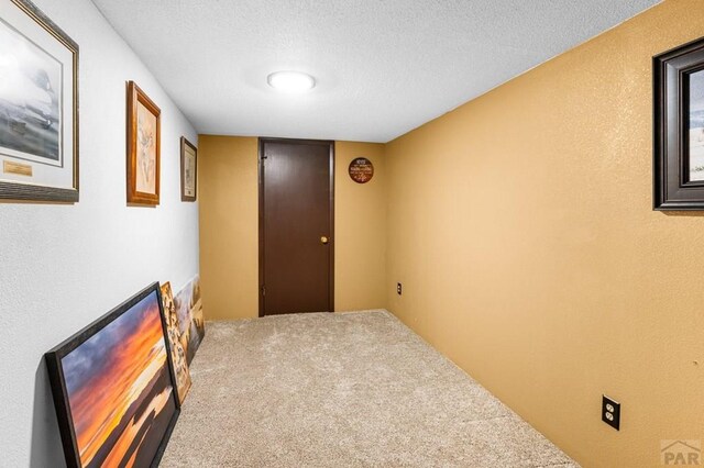 corridor with carpet and a textured ceiling