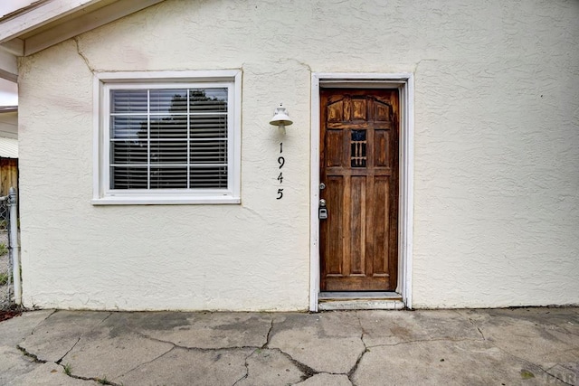 view of exterior entry featuring stucco siding