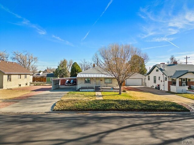 view of front of house featuring a carport, a residential view, concrete driveway, and a front lawn