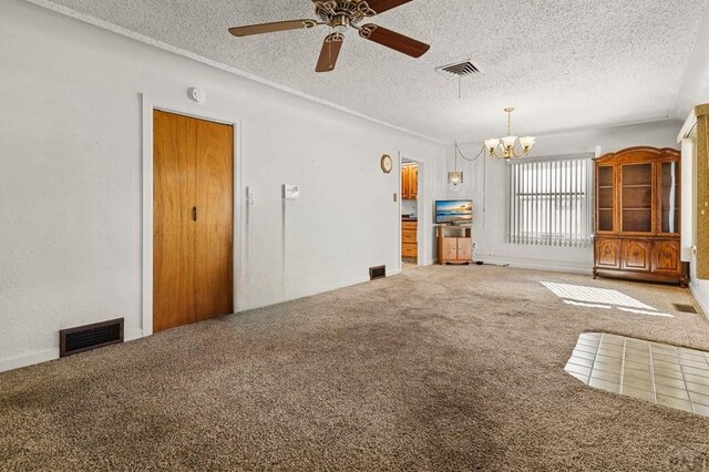 unfurnished living room featuring carpet floors, visible vents, a textured ceiling, and ceiling fan with notable chandelier