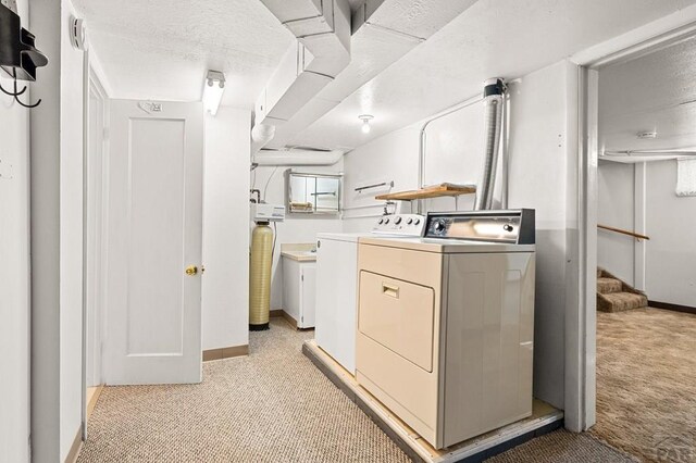 laundry room featuring laundry area, light colored carpet, independent washer and dryer, and baseboards