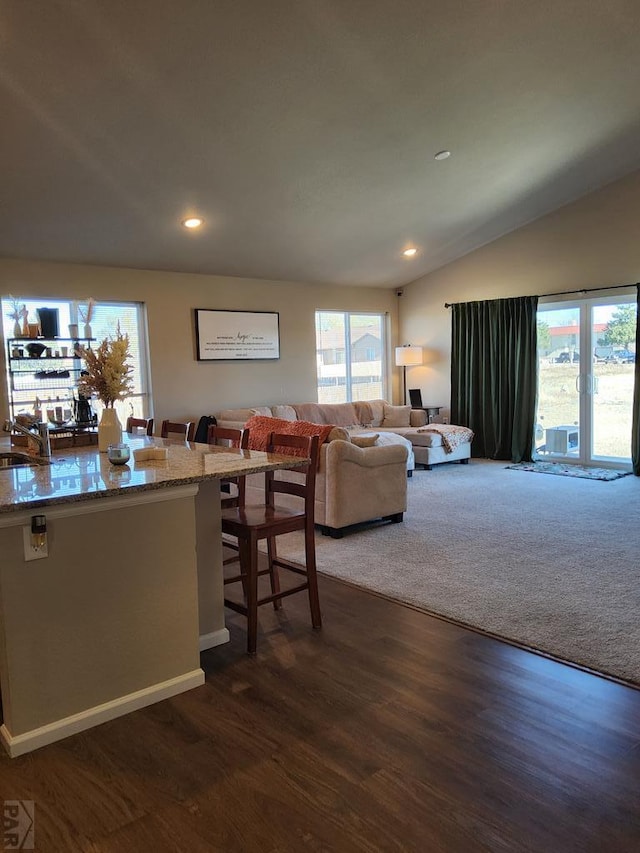 dining space with plenty of natural light, vaulted ceiling, dark wood finished floors, and recessed lighting