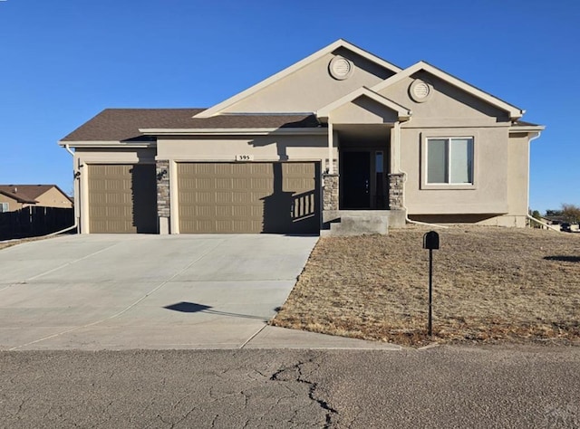 view of front of house featuring stone siding, driveway, an attached garage, and stucco siding