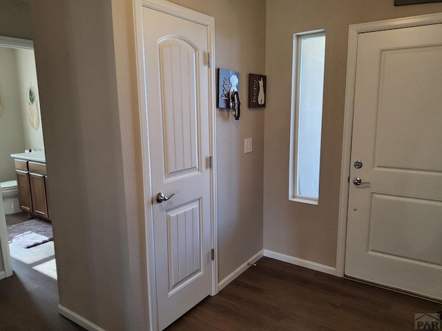 foyer entrance featuring dark wood-type flooring and baseboards