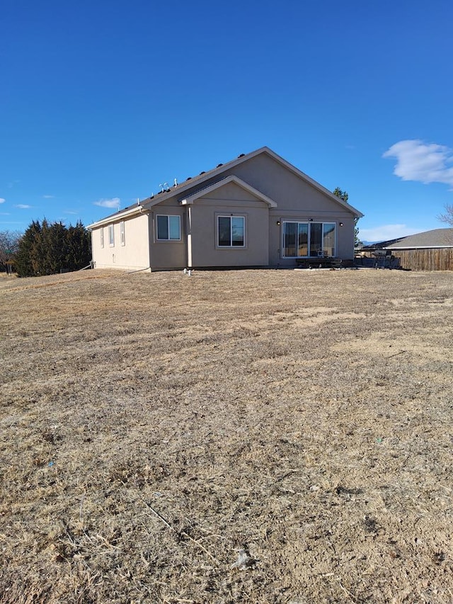 rear view of house featuring fence