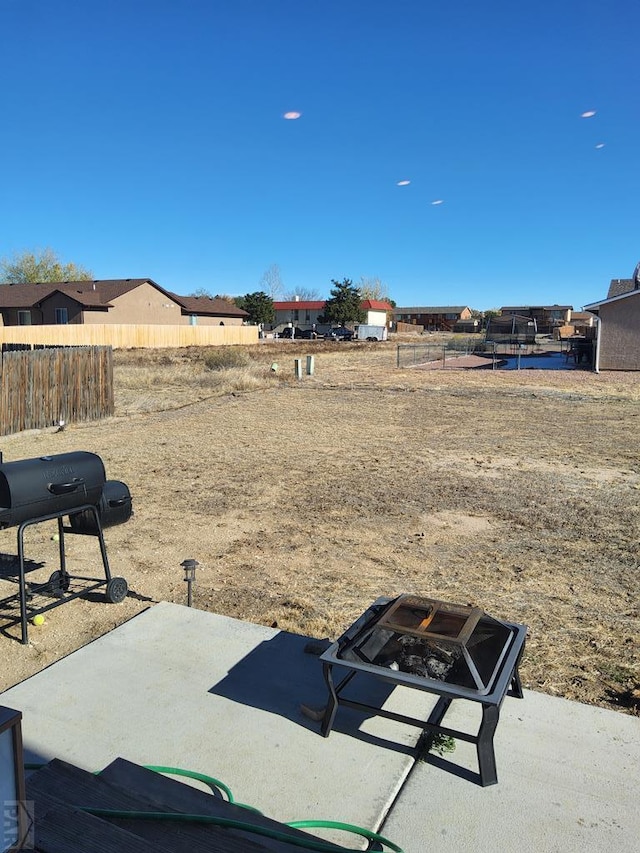 view of yard with an outdoor fire pit, a patio area, and fence