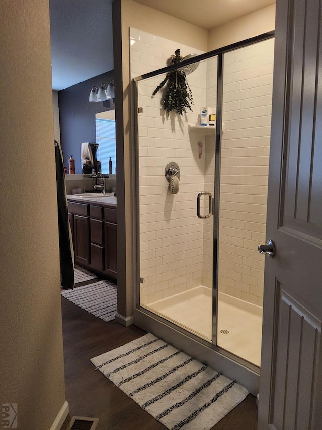 full bath featuring visible vents, a stall shower, wood finished floors, and vanity