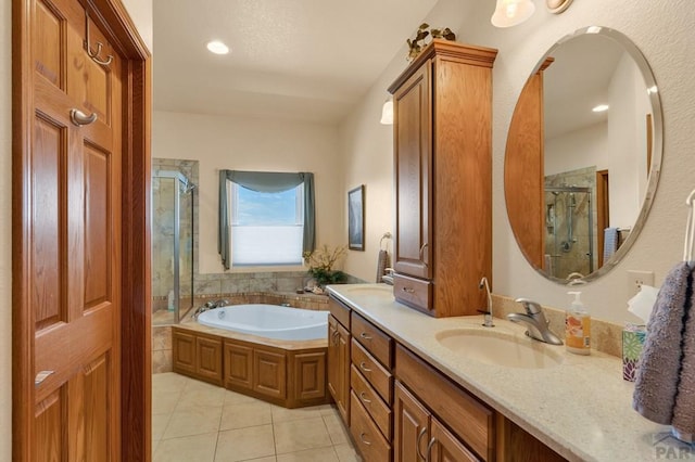 bathroom featuring a stall shower, a garden tub, a sink, and tile patterned floors