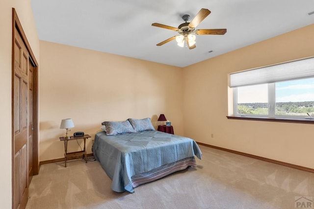 bedroom featuring light carpet, visible vents, baseboards, ceiling fan, and a closet