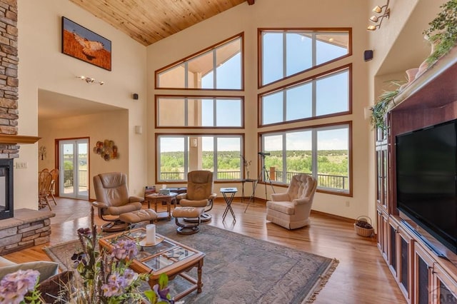 living area with light wood finished floors, wood ceiling, a fireplace, and a wealth of natural light