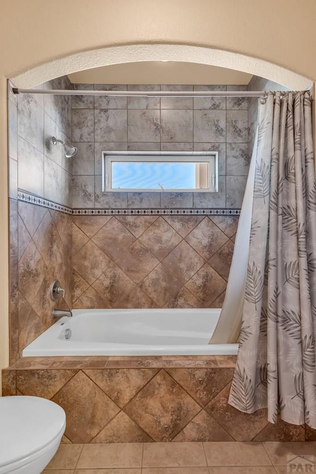 full bath with toilet, tiled shower / bath, and tile patterned floors