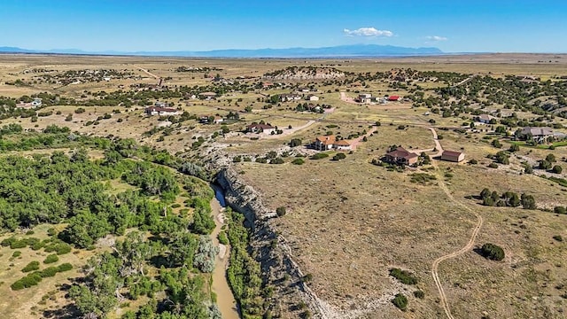 birds eye view of property featuring a mountain view and view of desert