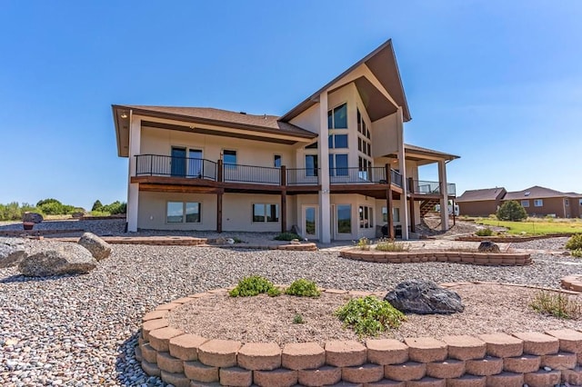 rear view of property featuring stairway and stucco siding