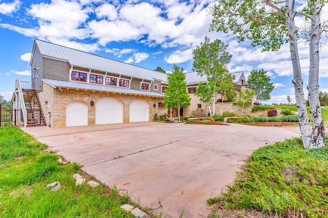 6430 Signal Mountain Rd, Beulah, CO 81023 - view of front of property with an attached garage, concrete driveway, stone siding, stairs, and metal roof