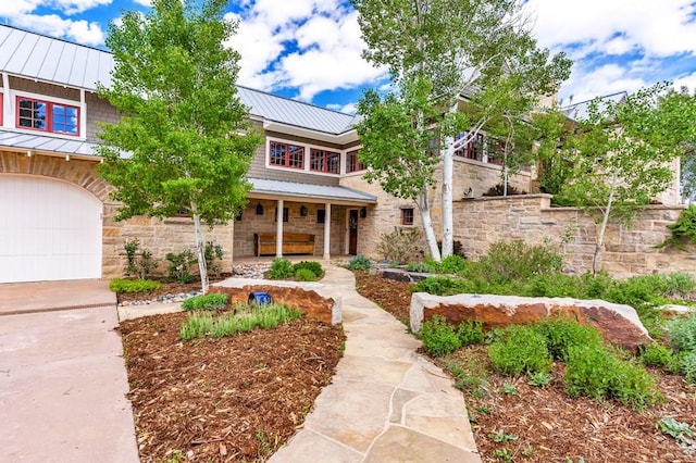 6430 Signal Mountain Rd, Beulah, CO 81023 - view of front of house featuring a standing seam roof, stone siding, metal roof, a porch, and concrete driveway