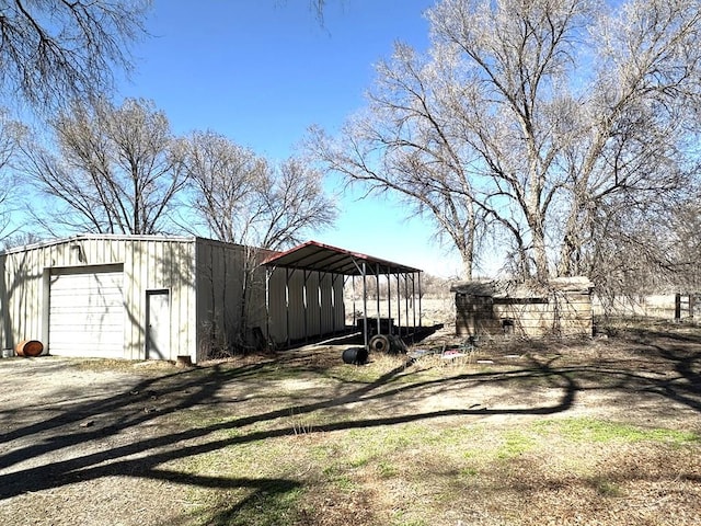 exterior space with a carport, a garage, driveway, and an outdoor structure