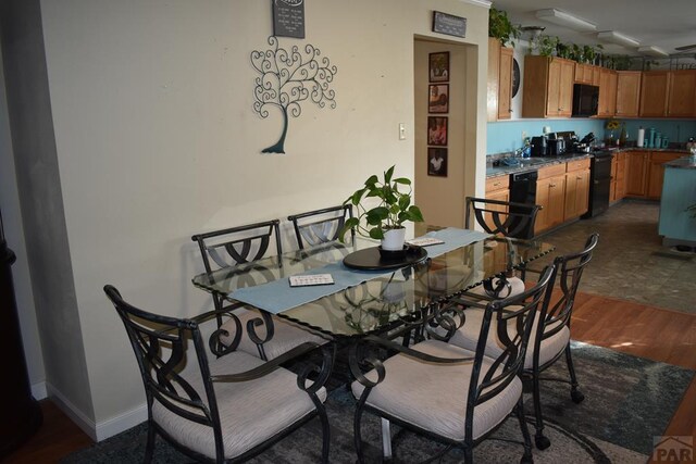 dining area with baseboards and dark wood-style flooring