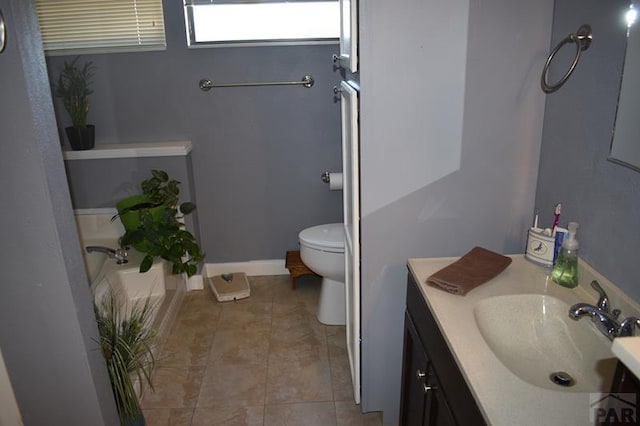 bathroom with toilet, tile patterned flooring, baseboards, and vanity