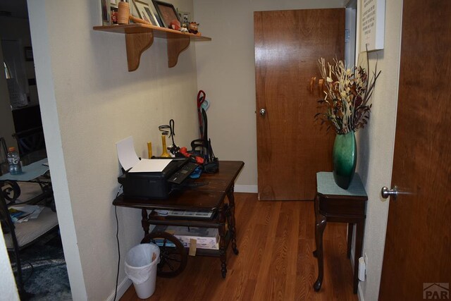 interior space featuring baseboards and wood finished floors