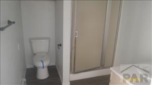 bathroom featuring toilet and a shower stall