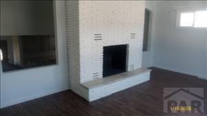 unfurnished living room featuring dark wood-style floors, a fireplace, and baseboards