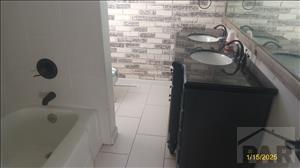 bathroom with a sink, double vanity, tub / shower combination, and tile patterned flooring