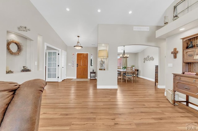 1284 N Challenger Dr, Pueblo West, CO 81007 - living room featuring lofted ceiling, light wood-type flooring, arched walkways, baseboards, and recessed lighting