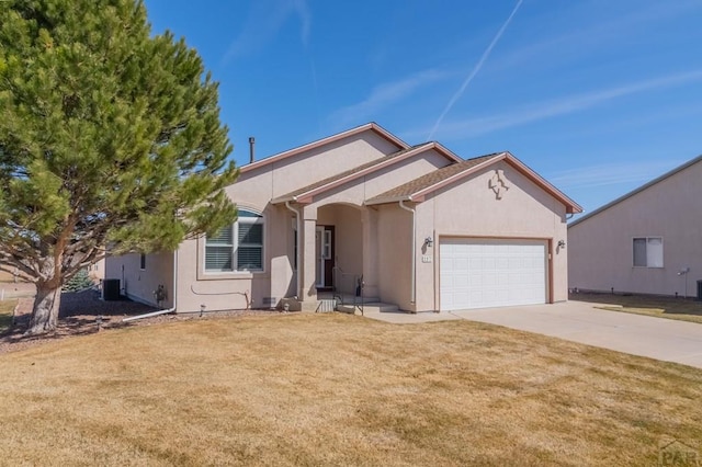 single story home with a garage, a front lawn, concrete driveway, and stucco siding