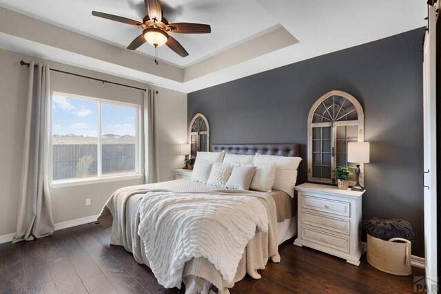 4288 Cedarweed Blvd, Pueblo, CO 81001 - bedroom featuring dark wood-type flooring, a tray ceiling, and ceiling fan